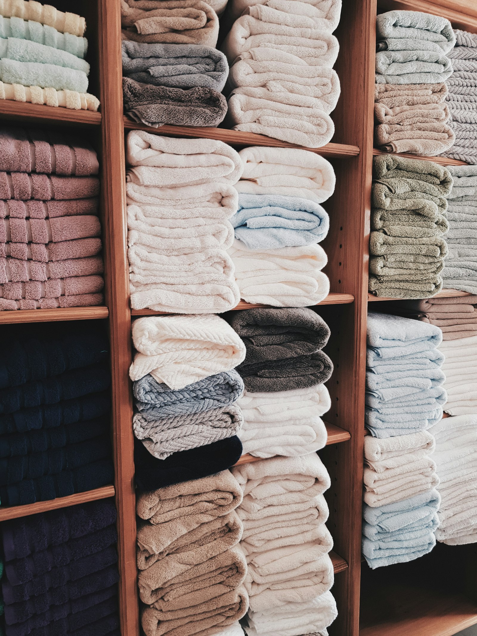 Folded towels and linen on shelves - Dora Ironing Service
